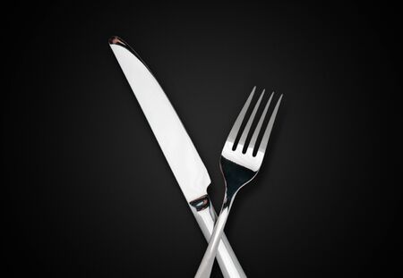 cake fork on black background. Close-up of stainless fork with copy space.