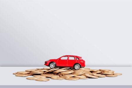 Golden coins and toy car on  backgroundの写真素材