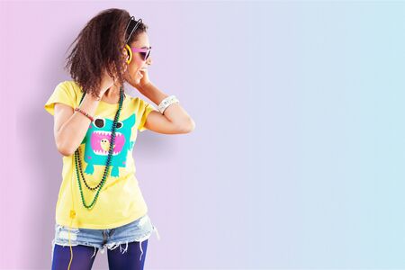 Full-length portrait of carefree brunette woman in shorts jumping while listening music. Indoor...