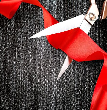Scissors cutting red ribbon