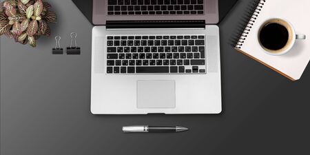 Elegant black office desktop with laptop and  cup of coffee. Top view