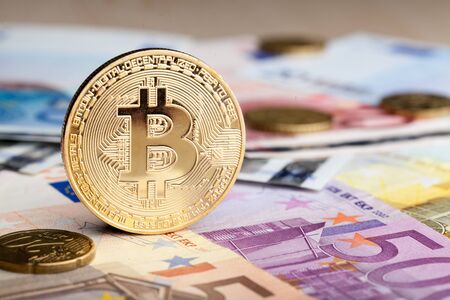 Cryptocurrency physical green bitcoin coin over the euro money.の写真素材