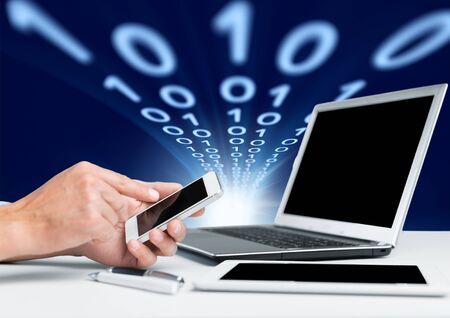Man hand working with smartphone with computer background. Technology.