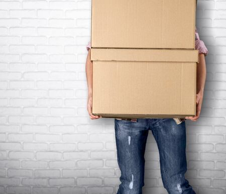 Man with cardboard boxes on brick backgroundの写真素材