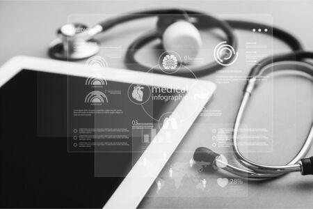 Digital tablet with stethoscope on wooden tableの写真素材