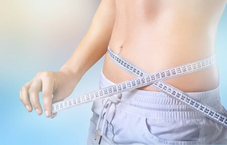 Close up of a slim waist with measuring tape.の写真素材