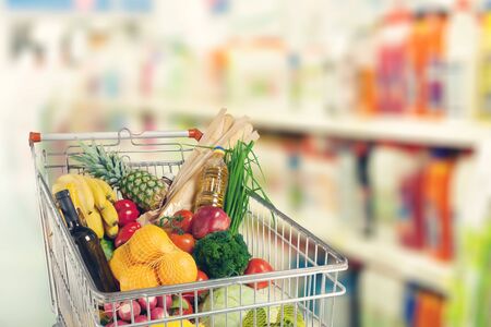 Shopping cart filled with various groceriesの写真素材