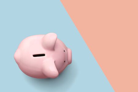 Pink piggy bank isolated on blue and pink pastel colorful trendy geometricの写真素材