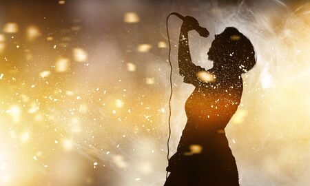 Singer holding a microphone on abstract background
