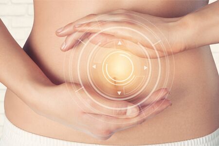 Close up of woman's hands made heart on belly isolated on white background.health care concept.の写真素材