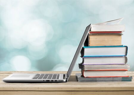 Stack of books with laptop on tableの写真素材