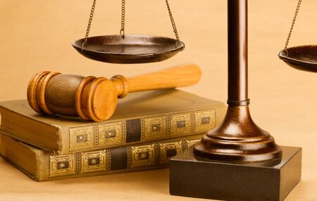 Closeup of Gavel on Books with Scale on Background
