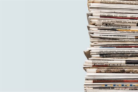 Pile of newspapers on white backgroundの写真素材