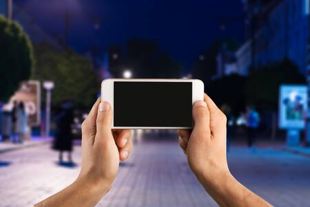 Hand with phone on city background