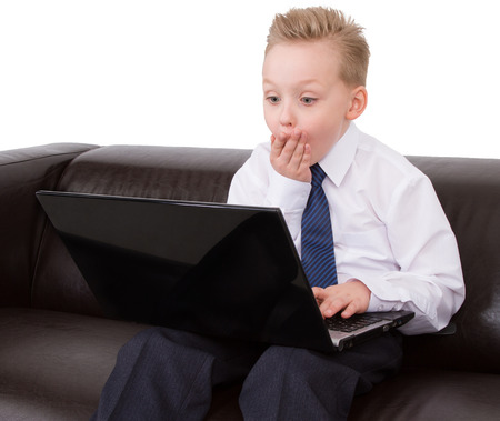 confused boy in suit looking at the computerの写真素材