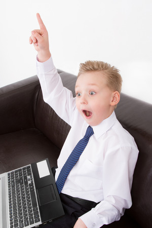 Young Businessman boyboy in suit sitting on sofa at the computer. Eurekaの写真素材