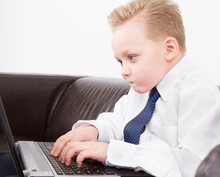 confused boy  in suit working at the computerの写真素材