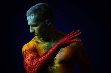 Muscle man with fantasy body art looking at the side. Copyspaceの写真素材