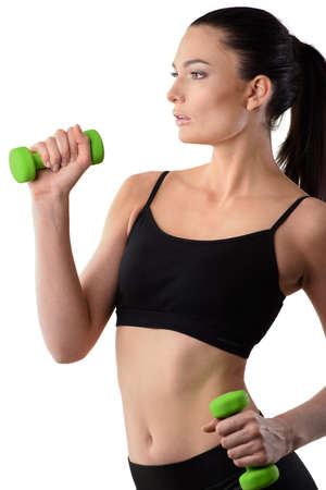 Fitness woman working out with green dumbbell looking at the side on isolated white background. Fitness conceptの写真素材