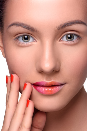 Beautiful young woman with colorful lips makeup and red nails looking at the camera. Close up head shotの写真素材
