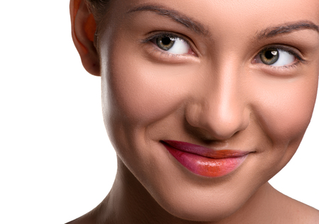 Close up head shot. Young smiling woman with colorful lips make up on isolated white looking at the sideの写真素材