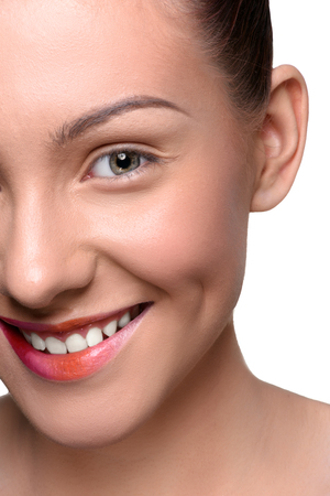 Half face of cheerful, happy young woman with colorful lips makeup looking at the camera. Close up head shotの写真素材