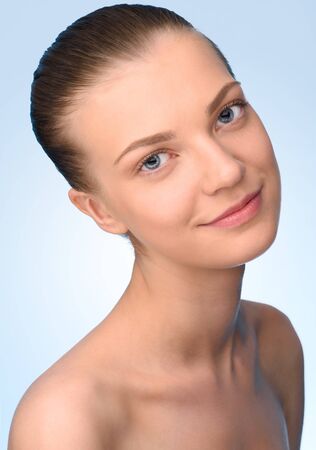 Portrait of beautiful young woman over light blue background looking at camera.  High resolutionの写真素材