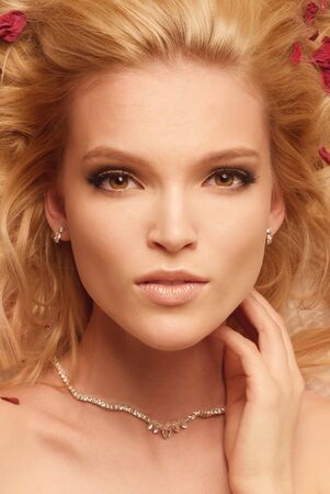 Close up shot of blonde gorgeous woman with stale roses leaf at the curlsの写真素材