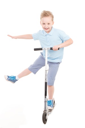 Little boy in shorts and shirt with scooter isolated on white.の写真素材