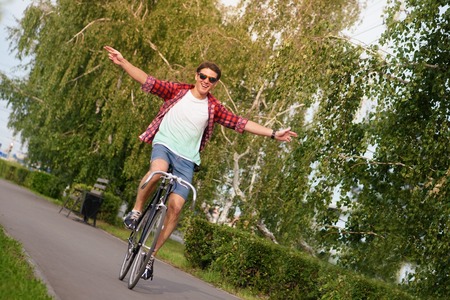 Hipster on bike at the city with no hands.の写真素材