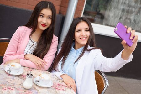 Happy Young asian women making selfie photo on smartphone outdoors.の写真素材