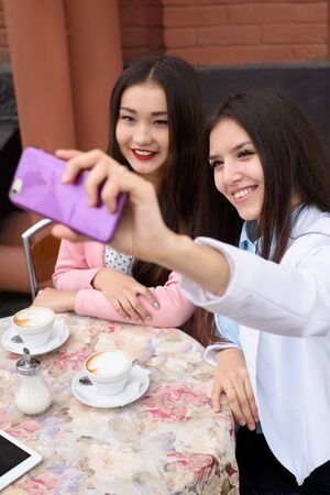 Happy Young asian women making selfie photo on smartphone outdoors.の写真素材