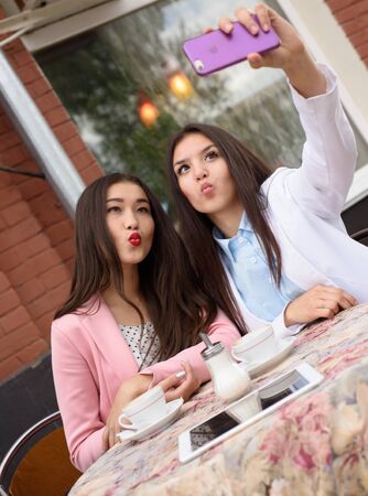 Happy Young asian women making selfie photo on smartphone outdoors.の写真素材
