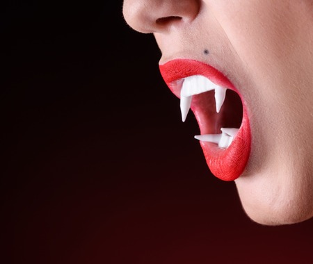 Close up shot of woman vamire mouth with white fangs.の写真素材