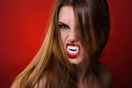 Lady Vampire Style. Portrait of Brunette Woman over red background.の写真素材