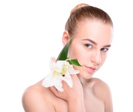 Beauty of health young woman posing with lily looking at the camera. Isolated on white backgroundの写真素材