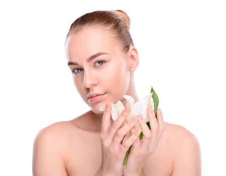 Beauty of health young woman posing with lily looking at the camera. Isolated on white backgroundの写真素材