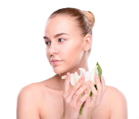 Beauty of health young woman posing with lily looking at the side. Isolated on white backgroundの写真素材