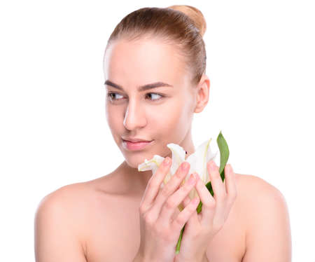 Beauty of health young woman posing with lily looking at the camera. Isolated on white backgroundの写真素材