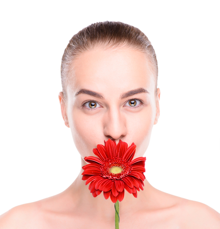 Cheerful beautiful woman with red gerbera. Isolated on white background.の写真素材