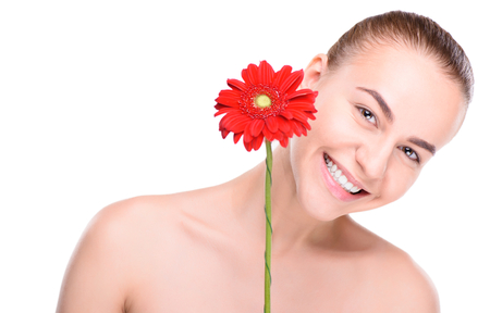 Cheerful beautiful woman with red gerbera. Isolated on white background.の写真素材