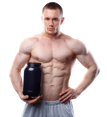 Bodybuilder holding a black plastic jar with whey protein isolated on white background.の写真素材