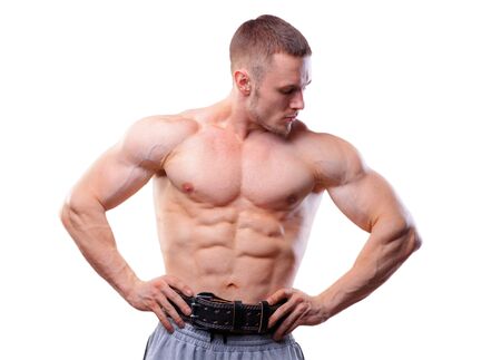 Muscular man with lifting belt posing over white isolated background.の写真素材