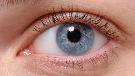 Macro shot of blue eye with makeup looking at the side. Model with perfect skinの写真素材