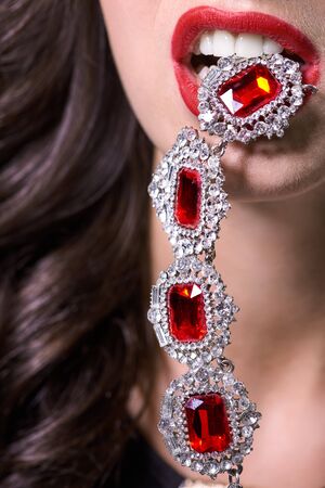 Macro shot. Red lips with jewelery pendant.の写真素材