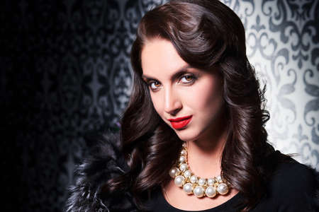 Portrait of elegant brunette retro woman wearing silver fox fur over vintage background.の写真素材