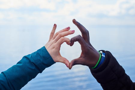 Interational love.White and black hands make heart symbolの写真素材