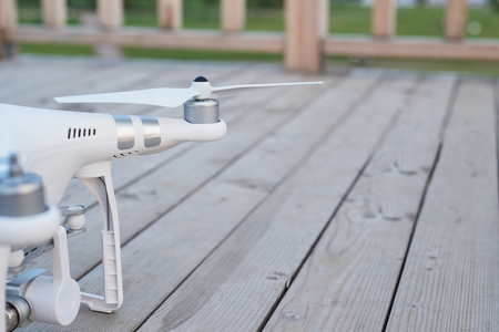 Quadrocopter close-up. Selective focus on propeller. Landed drone at wood surface.の写真素材