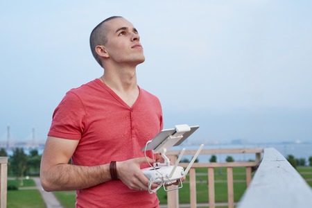 Young man operating a drone remote control console.