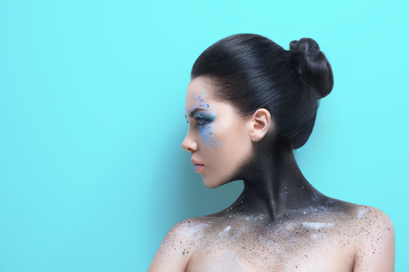 Fashion woman with Fantasy make up over blue wallの写真素材